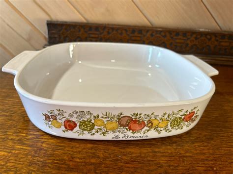 A Spice of Life marked as <b>Le Romarin</b> (Rosemary) <b>Corningware</b> dish 10" square and 12" across at the handles and the matching clear lid. . Le romarin corningware